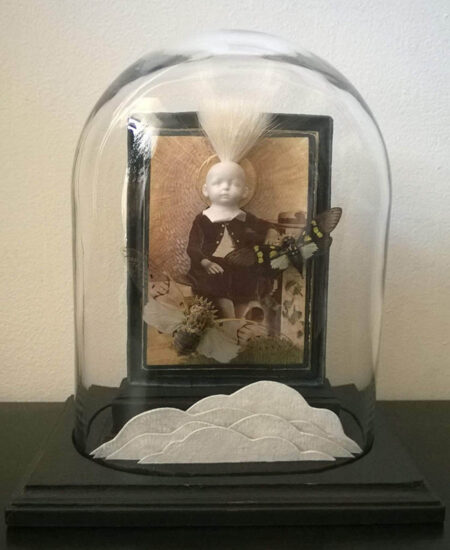 assemblage of moths and ceramic bust of baby on antique photograph, inside glass dome with 2d clouds in foreground; memento, shrine, honoring the dead